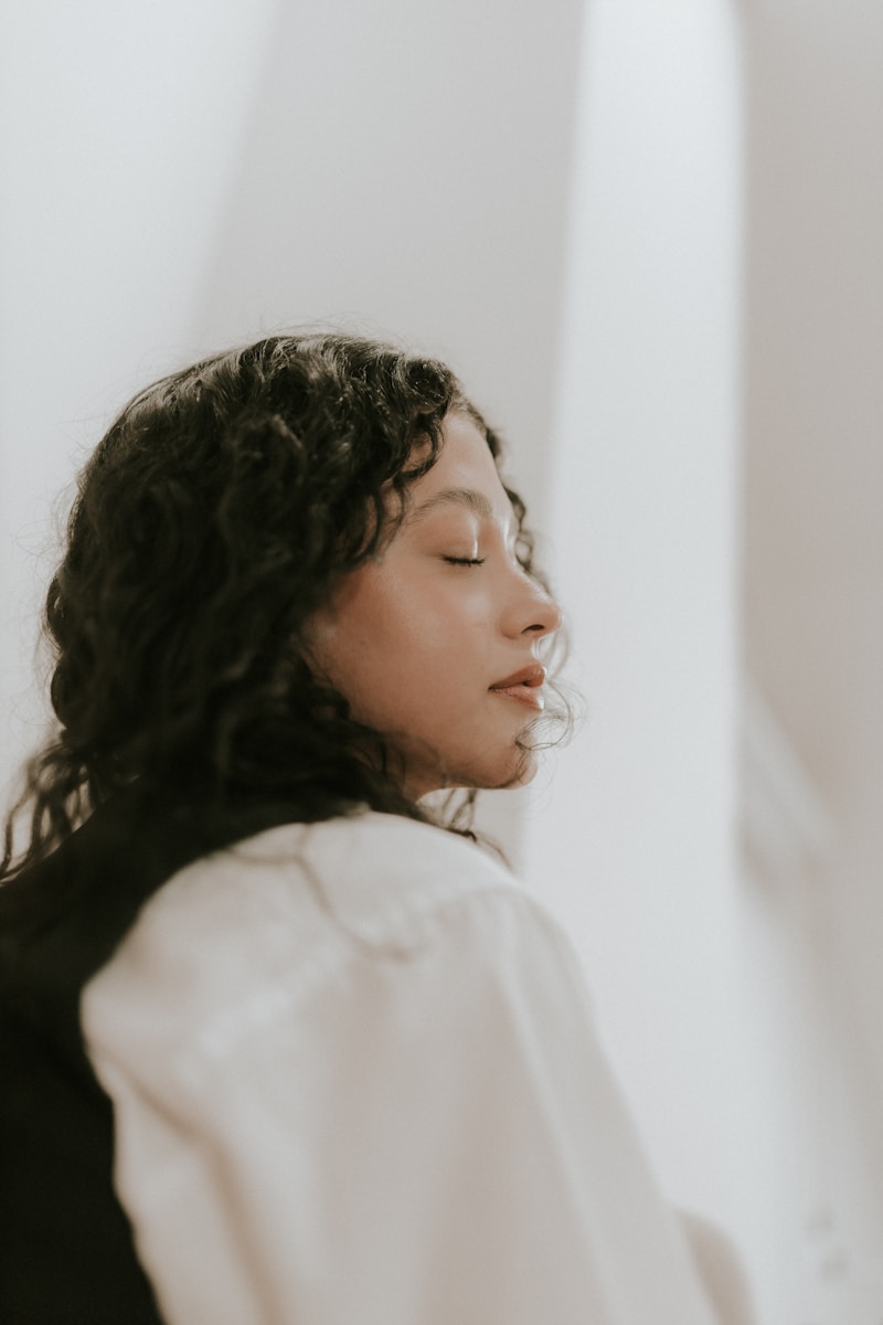 A woman with her eyes closed standing in a room