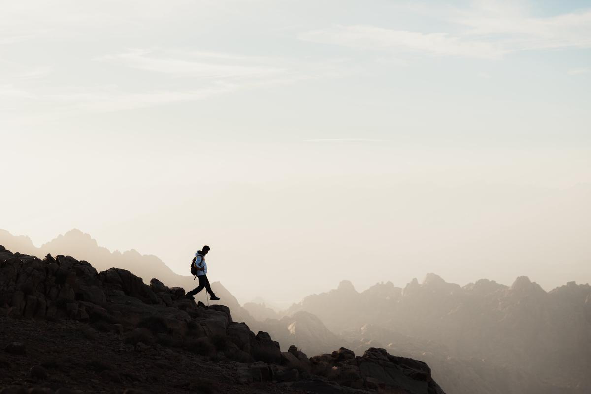 Image of a person climbing a mountain, representing the journey of credit recovery for someone after bankruptcy.